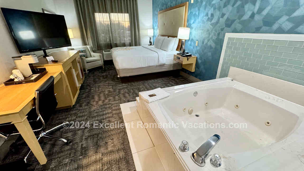 Large corner jetted tub for 2 with a King Bed and desk in a room at the Best Western Plus Houston Atascocita Inn & Suites.