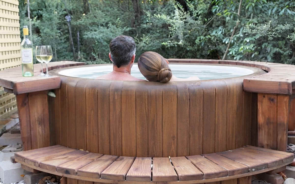 Romantic Couple Enjoying a Glass of Wine in their Private Outdoor Hot Tub at Blisswood B&B in Texas