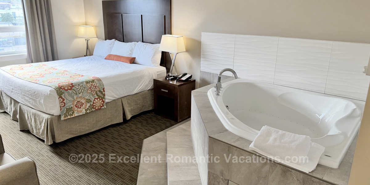 Large 2-Person Corner Jetted Tub Next to a King Bed in a Suite at the Coast Oliver Hotel in Oliver BC