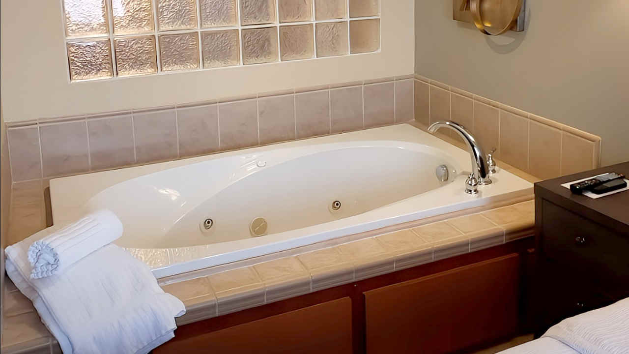 Jetted Tub Beside a Bed in a Room at Copperleaf Hotel, Appleton WI