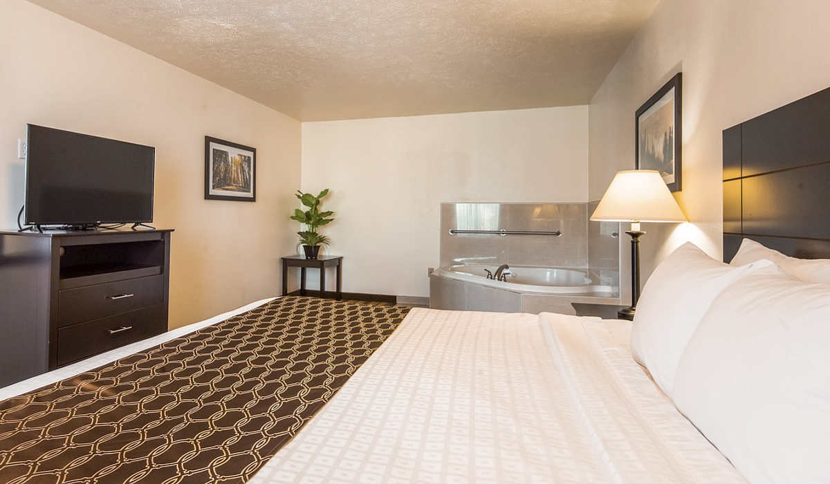 King Bed with a Corner Whirlpool Tub in a Suite at the Best Western Visalia, CA