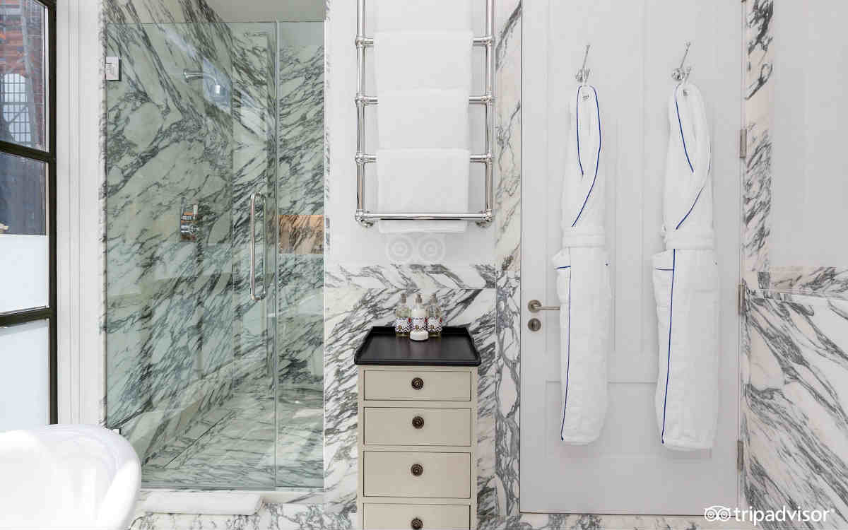 Beautiful Whitby Hotel bathroom with walk-in shower and robes.