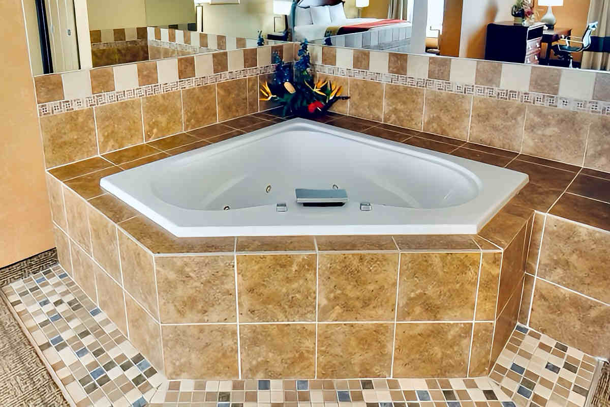 Corner Whirlpool Tub in a Room at Quality Suites Close to Buffalo, NY