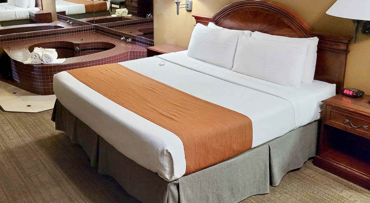 King Bed and Whirlpool Tub in a Room at the Dynasty Suites Redlands Hotel.