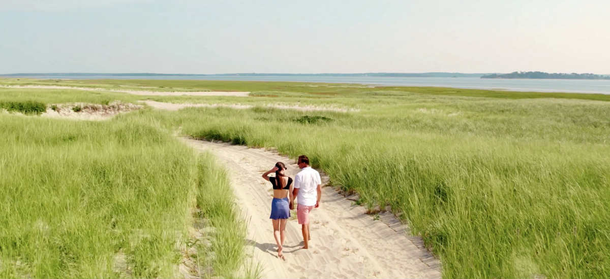 Couple Walking and Holding Hands Near the Shore on Cape Cod, MA.