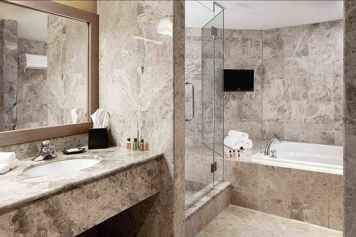 Sheraton Laval Hotel Suite Marble Bathroom with a Jetted Tub and Walk-In Shower
